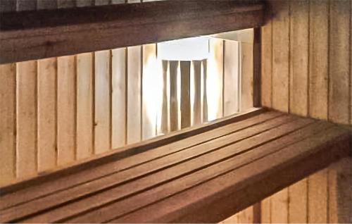 a window in a wooden wall with a refrigerator at Nice Home In Överkalix With Sauna in Överkalix