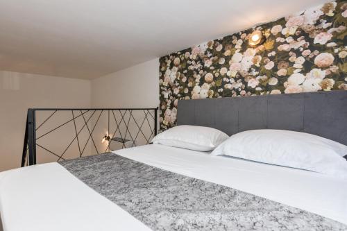sypialnia z łóżkiem z kwiatową ścianą w obiekcie Apartments Tija Exclusive w mieście Zadar