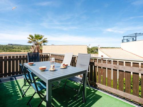 une table et des chaises sur le balcon d'une maison dans l'établissement Pavillon climatisé avec piscine, parking à Narbonne-Plage - FR-1-409-203, à Narbonne