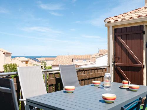- une table bleue sur un balcon avec vue sur l'océan dans l'établissement Pavillon climatisé avec piscine, parking à Narbonne-Plage - FR-1-409-203, à Narbonne
