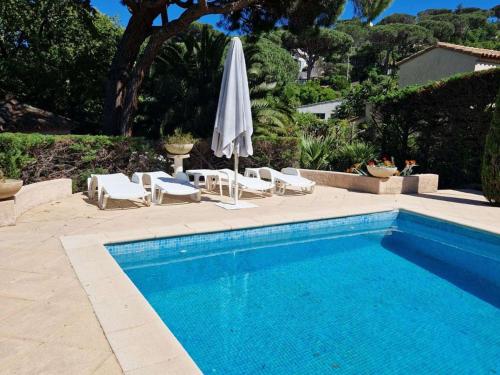 - une piscine avec un parasol, des chaises, une table et des chaises dans l'établissement Sainte Maxime Sémaphore : Haut de Villa T4, Piscine, Terrasse, Clim, Proche Mer - FR-1-226-531, à Sainte-Maxime