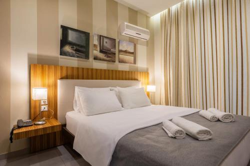 a bedroom with a large bed with towels on it at Agrilia Hotel Adults Only in Laganas