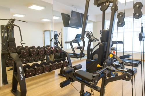 a gym with treadmills and machines in a room at Hotel Marfil in San Antonio