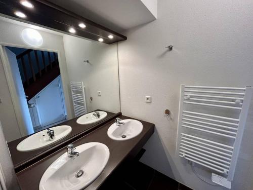 a bathroom with two sinks and a large mirror at 110 - Appartement duplex 6 personnes vue sur Golf. in Frehel
