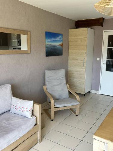 a room with a bed and a chair and a table at 110 - Appartement duplex 6 personnes vue sur Golf. in Frehel