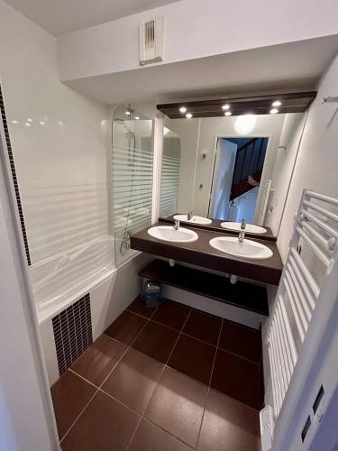 a bathroom with two sinks and a large mirror at 110 - Appartement duplex 6 personnes vue sur Golf. in Frehel