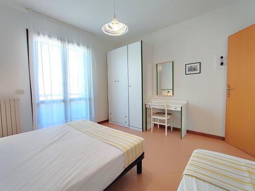 a bedroom with a bed and a table and a desk at Tamerici in Cavallino-Treporti