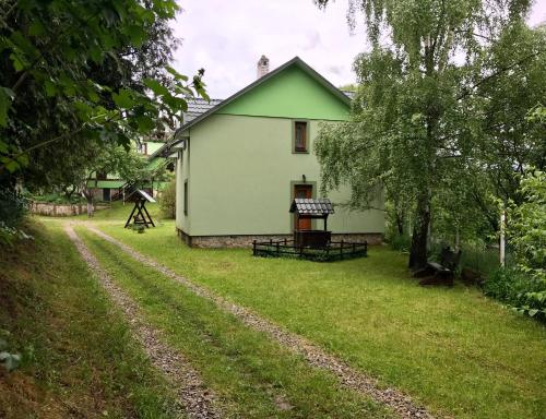 una casa blanca con un árbol y un camino de tierra en Goryanka Hotel, en Mykulychyn