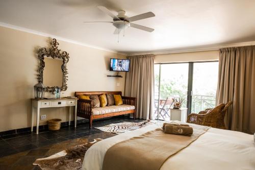 ein Schlafzimmer mit einem Bett und einem Sofa in der Unterkunft Areena Riverside Resort in Kwelera