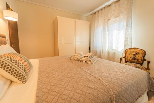 a bedroom with a bed with two towels on it at Efi's Luxury Apartment in Kavala