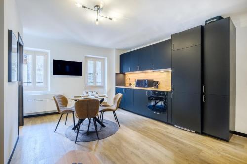 une cuisine avec une table et des chaises dans une pièce dans l'établissement Le Turbiasque - apt climatisé - 500m de la plage, à La Turbie