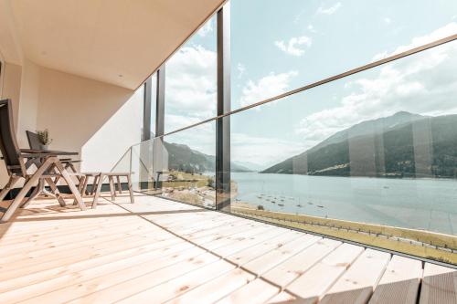 a balcony with a view of the water and mountains at Seehotel Panorama Relax in Resia