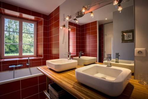 une salle de bain avec deux lavabos et un grand miroir dans l'établissement Ker Karamel, tennis, au calme, à Perros-Guirec