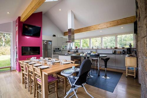 une grande cuisine avec une table et des chaises en bois dans l'établissement Ker Karamel, tennis, au calme, à Perros-Guirec