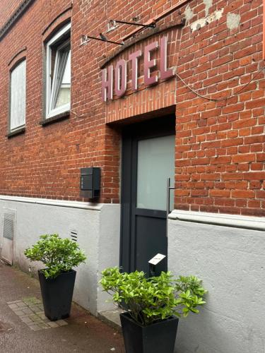 a hotel with two potted plants in front of a building at Borgo Antico Hotel in Fehmarn