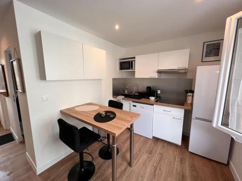 une petite cuisine avec une table en bois dans une pièce dans l'établissement Cosy Appart - 4 personnes, à Poitiers