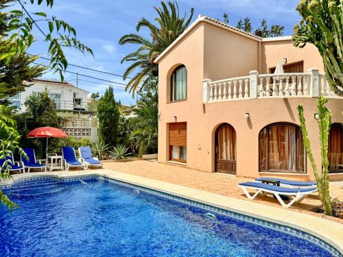 eine Villa mit einem Pool und einem Haus in der Unterkunft La AMISTAD Apartamento en Chalet con piscina compartida in Calpe