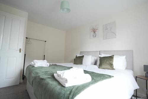 twee witte handdoeken op een bed in een slaapkamer bij Spacious 4 bedroom, perfect for contractors, families, private parking in Royal Wootton Bassett