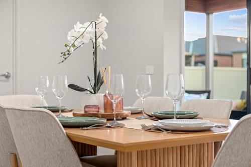 a wooden table with plates and wine glasses on it at A Ballarat bliss in Alfredton