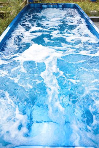 une piscine d'eau bleue recouverte de neige dans l'établissement Suite jacuzzi et sauna privatifs, à Volmerange-les-Mines