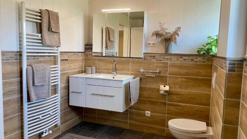 a bathroom with a sink and a toilet and a mirror at Ferienwohnung Schmid in Lautrach