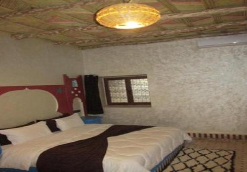 a bedroom with a large bed and a ceiling at SANDSTAR PALACE in Merzouga