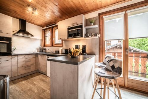 a kitchen with a island in the middle of a room at Appartement chalet - Le Caribou in Morzine