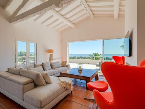 un salon avec un canapé, une table et des chaises dans l'établissement Holiday Home Les Rêves Bleus by Interhome, à Saint-Aygulf
