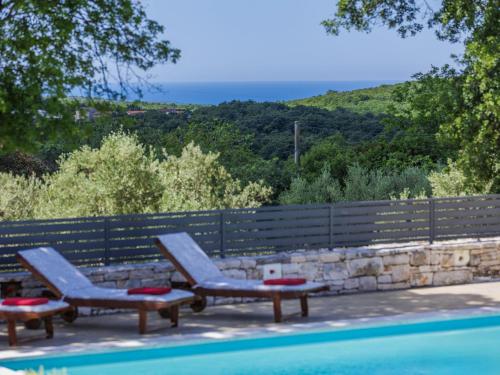 two lounge chairs sitting next to a swimming pool at Villa Fuma by Interhome in Bale
