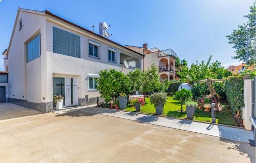 a large white house with a yard with plants at Apartment Fucane Iv in Medulin