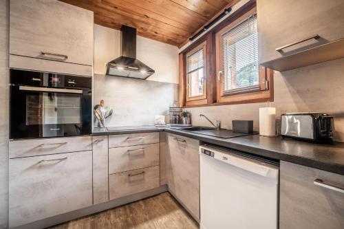 a kitchen with stainless steel appliances and wooden ceilings at Appartement chalet - Le Caribou in Morzine