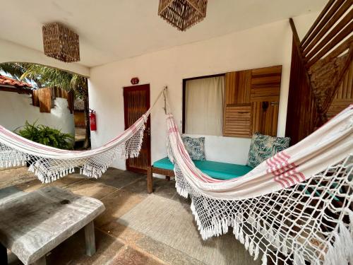 a room with two hammocks in a room at Pousada Maresia in Atins