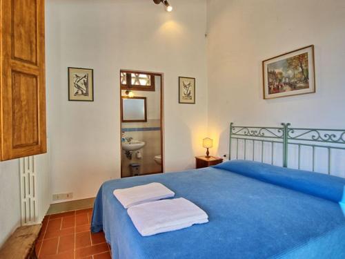 a bedroom with a blue bed with towels on it at Apartment L'Oleandro-12 by Interhome in Grassina