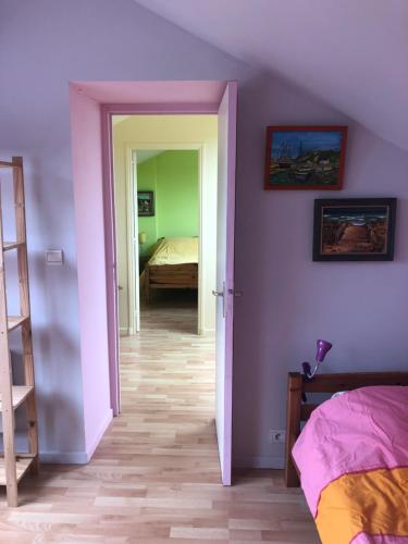 une chambre avec des murs violets et une chambre avec un lit dans l'établissement Les orchidées, à Houlgate