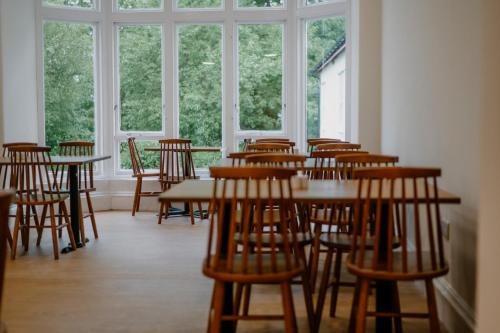 ein Raum voller Tische und Stühle mit Fenstern in der Unterkunft Rowardennan Youth Hostel in Rowardennan