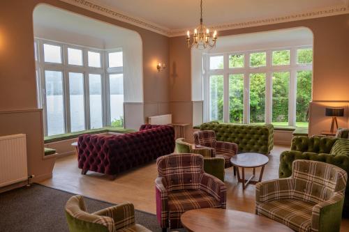 a waiting room with chairs and tables and windows at Rowardennan Youth Hostel in Rowardennan