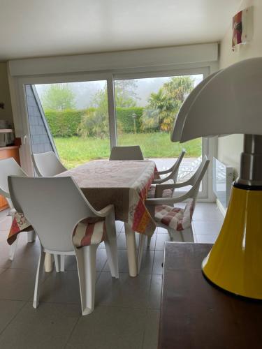 une salle à manger avec une table et des chaises et une fenêtre dans l'établissement Les orchidées, à Houlgate