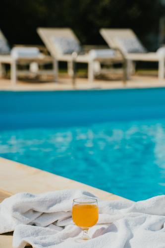 a glass of wine sitting next to a swimming pool at Paradise Art Hotel in Andros