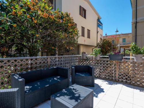 - deux chaises et un canapé sur une terrasse avec clôture dans l'établissement Holiday Home Elena by Interhome, à Castiglione della Pescaia