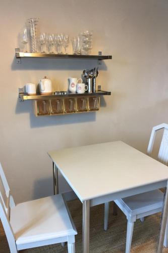 une table blanche et deux chaises dans une pièce dans l'établissement Brise Marine, à Erquy