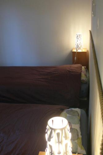 une chambre avec un lit et une table avec une lampe dans l'établissement Au pied des rochers, à Erquy