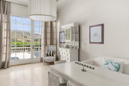 Biały salon z kanapą i stołem w obiekcie Paradise Art Hotel w mieście Andros