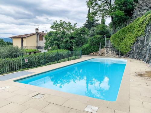 a blue swimming pool in front of a house at Apartment Adelaide by Interhome in Albisano