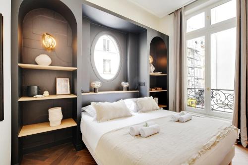 une chambre avec un grand lit avec deux serviettes dessus dans l'établissement Magnifique Studio Montorgueil, à Paris