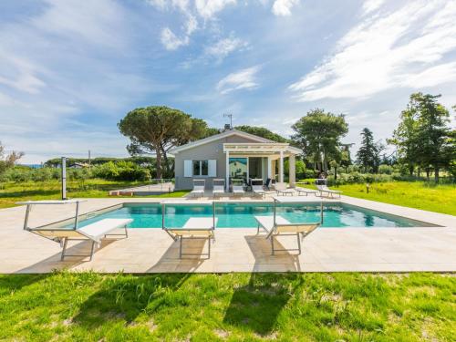 a swimming pool with chairs and a house at Holiday Home Veronica by Interhome in Cecina