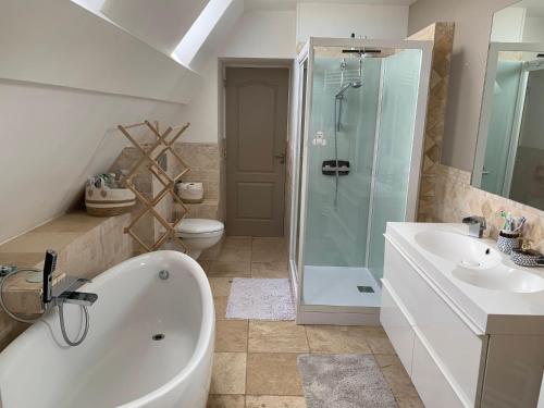 une salle de bain avec une baignoire, une douche et un lavabo dans l'établissement Longère bord de mer avec grand jardin fleuri, à Géfosse-Fontenay