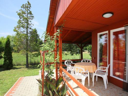 un porche de una casa con mesa y sillas en Chalet Rosso by Interhome en Balatonmáriafürdő