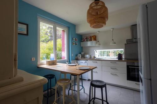 - une cuisine avec une table et des tabourets en bois dans l'établissement Ty Swannee, Ty Swannee maison familiale, à Trébeurden