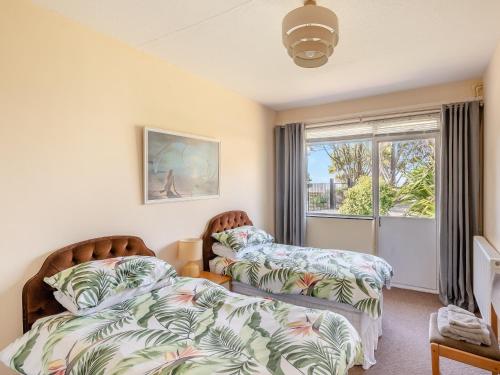 a bedroom with two beds and a window at Beach View Cottage in Felixstowe