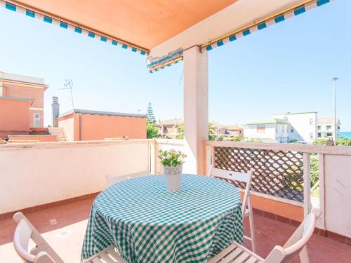 a table with a green and white table cloth on a balcony at Apartment Giuliana by Interhome in Torvaianica